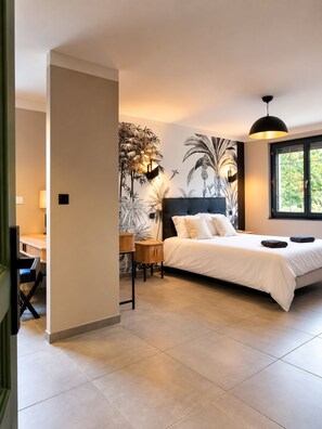 A bedroom with a large bed, a desk, and a wall mural. - New Listing (Le Pègue)