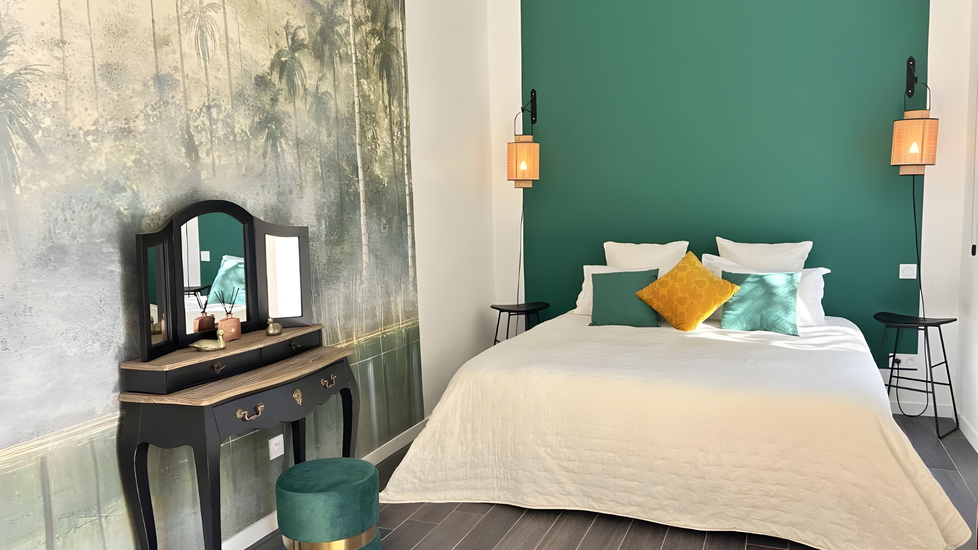 Een slaapkamer met een groot bed, een dressoir, een spiegel en twee wandlampen.