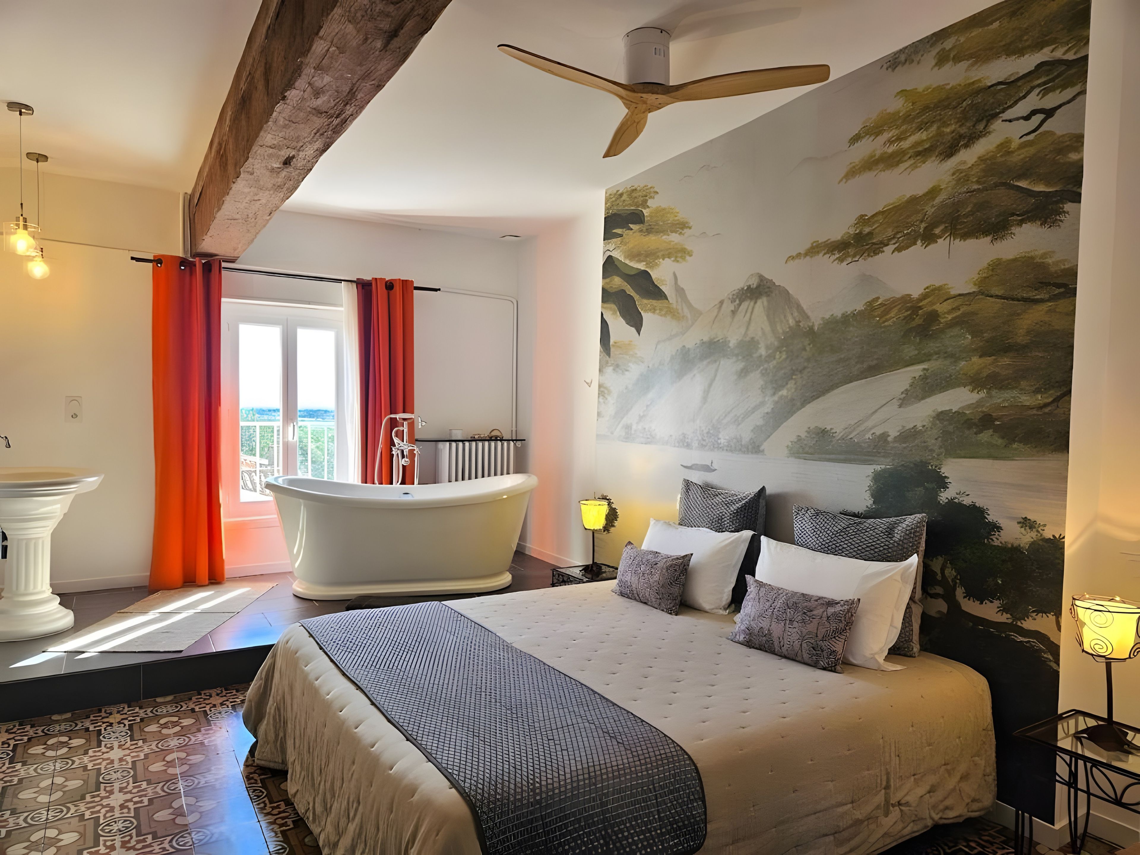Quarto moderno com uma cama grande, banheira e um mural de paisagem montanhosa.