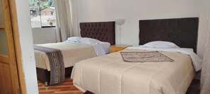 Une chambre d’hôtel avec deux lits, une fenêtre et une lampe.