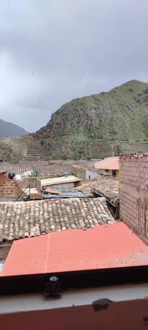 Un barrio residencial con casas adosadas, un edificio de techo rojo y montañas al fondo.