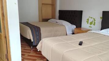 Une chambre d’hôtel avec deux lits, une armoire en bois et une petite table de chevet.