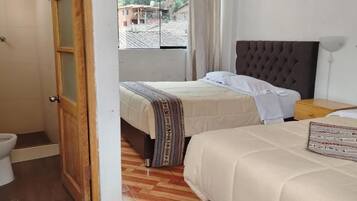 Une chambre d’hôtel avec deux lits, une porte en bois, une douche et une vue sur l’extérieur.