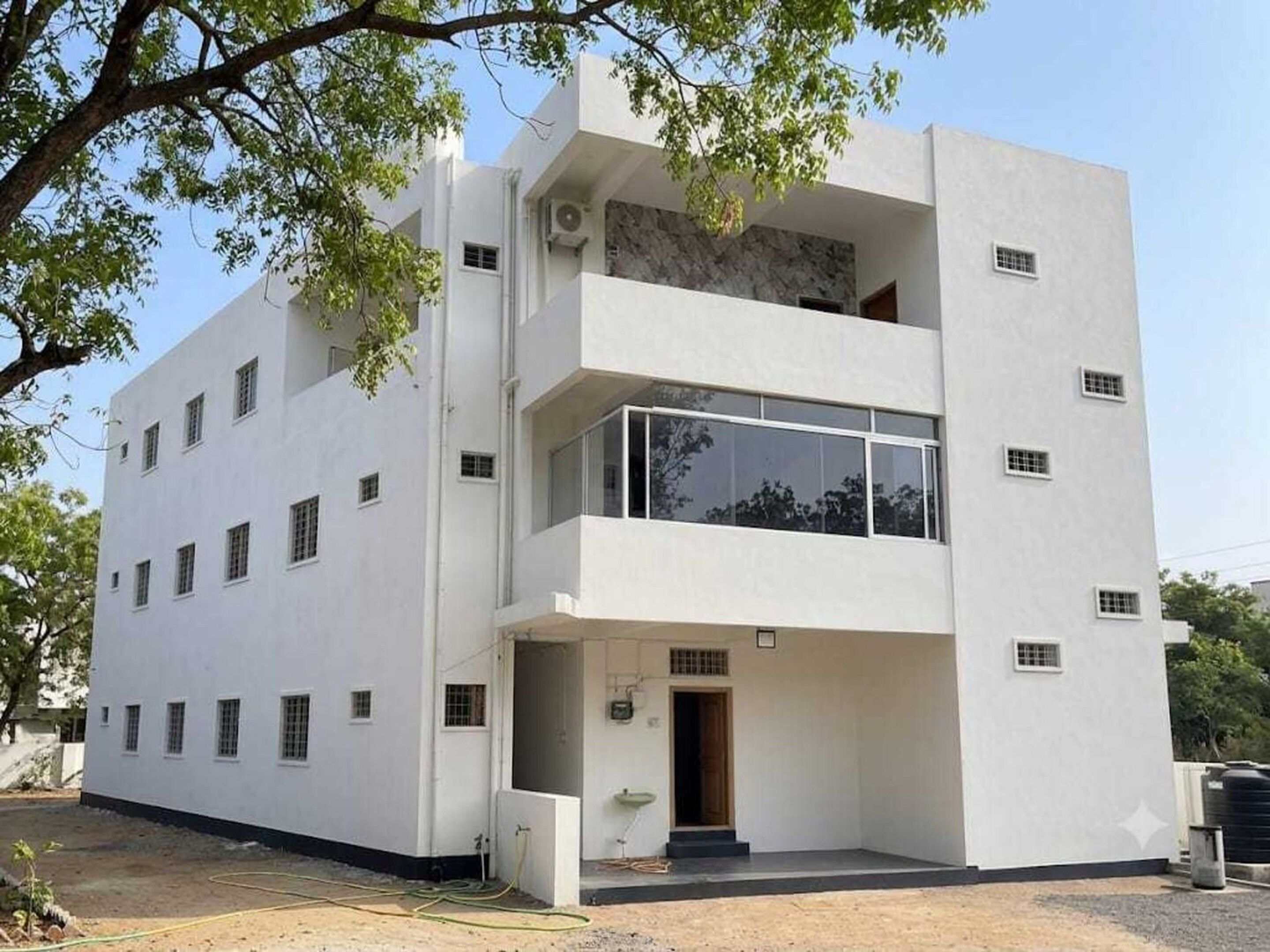 A modern two-story building with a flat facade, multiple windows, and a visible entrance.