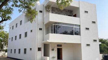 A modern two-story building with a flat facade, multiple windows, and a visible entrance.