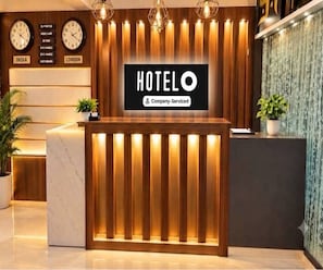 Eine Hotelrezeption mit Holzausstattung und vertikaler Beleuchtung.