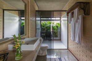 A modern bathroom with a glass shower enclosure, a bathtub, and a toilet. - Pousada Guata Porã  (Foz do Iguaçu)