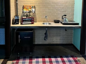 A compact kitchen with a toaster, kettle, and sink. - Pousada Guata Porã  (Foz do Iguaçu)