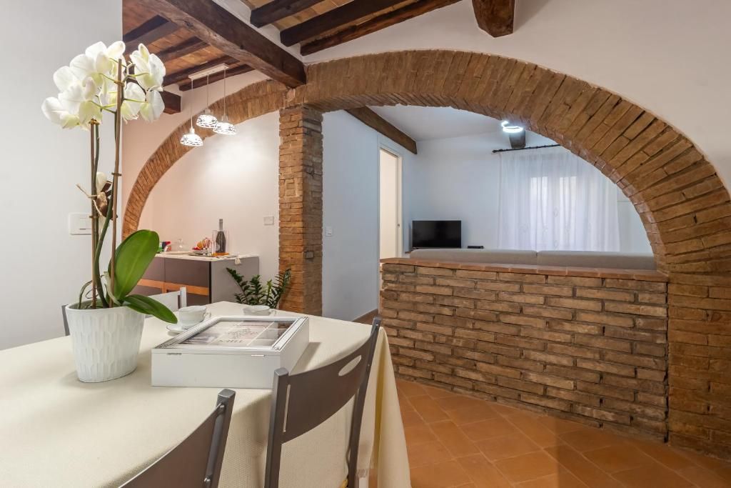 Un coin repas avec un mur en briques, une table avec des chaises et une plante en pot.