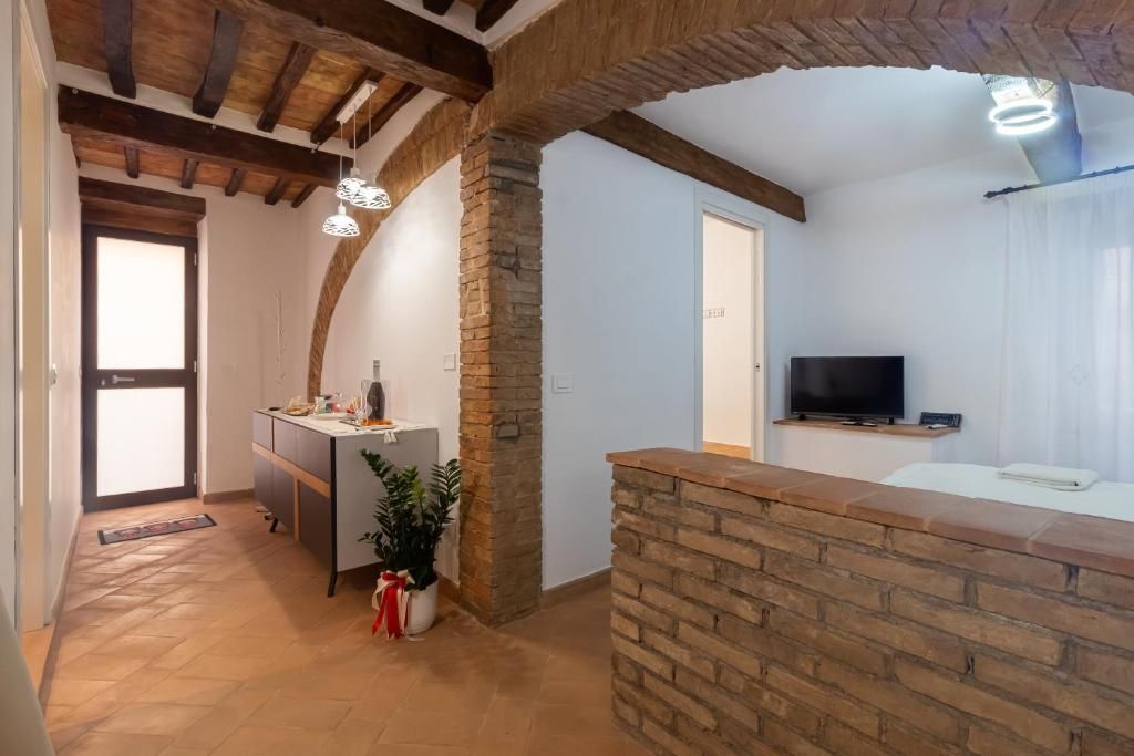 A modern kitchen with a built-in island, a dining area with a white table, and a TV mounted on the wall.