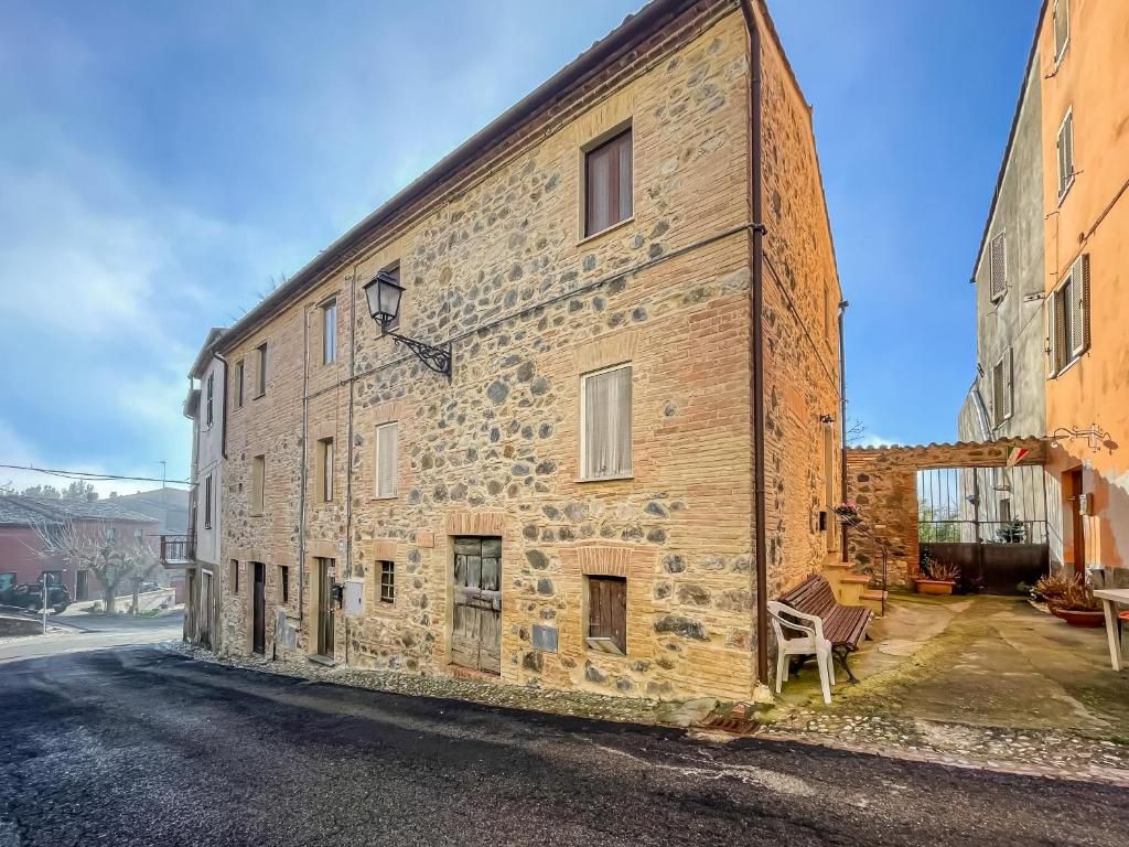 A stone building with multiple windows and a small outdoor seating area.