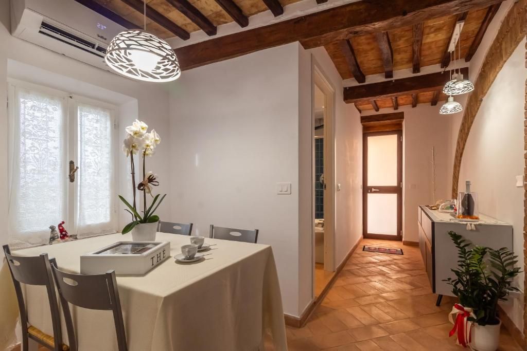 A dining area with a table set for four, a potted plant, and a book titled 'THE'.