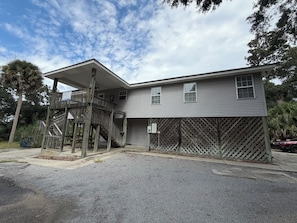 A two-story building with a wooden staircase leading to a covered porch. - Edisto 3BR Home~ Walk to Beach (Edisto Island)