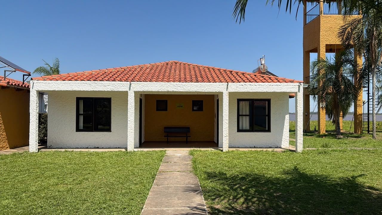 A two-story building with a red-tiled roof, a small porch, and a bench.