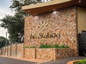 A hotel entrance with a stone facade and a logo above the name 'Hill Station' established in 1938.