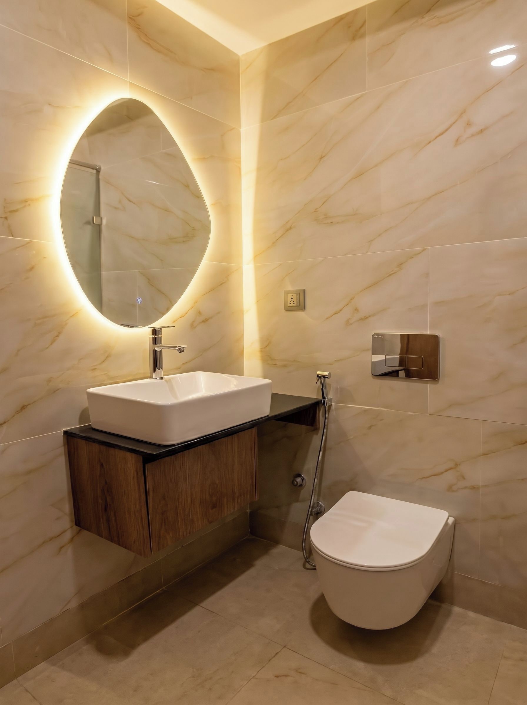 Un bany modern amb un lavabo, un rentamànega, un mirall i un vàter.