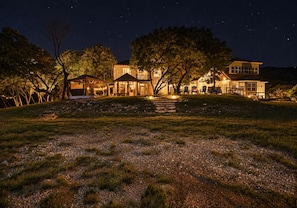A large house with multiple rooms, a covered outdoor area, and a stone pathway leading to the entrance.