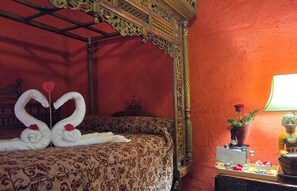 A room with a four-poster bed, a red textured wall, and a decorative lamp. - New Listing (Orgaz)