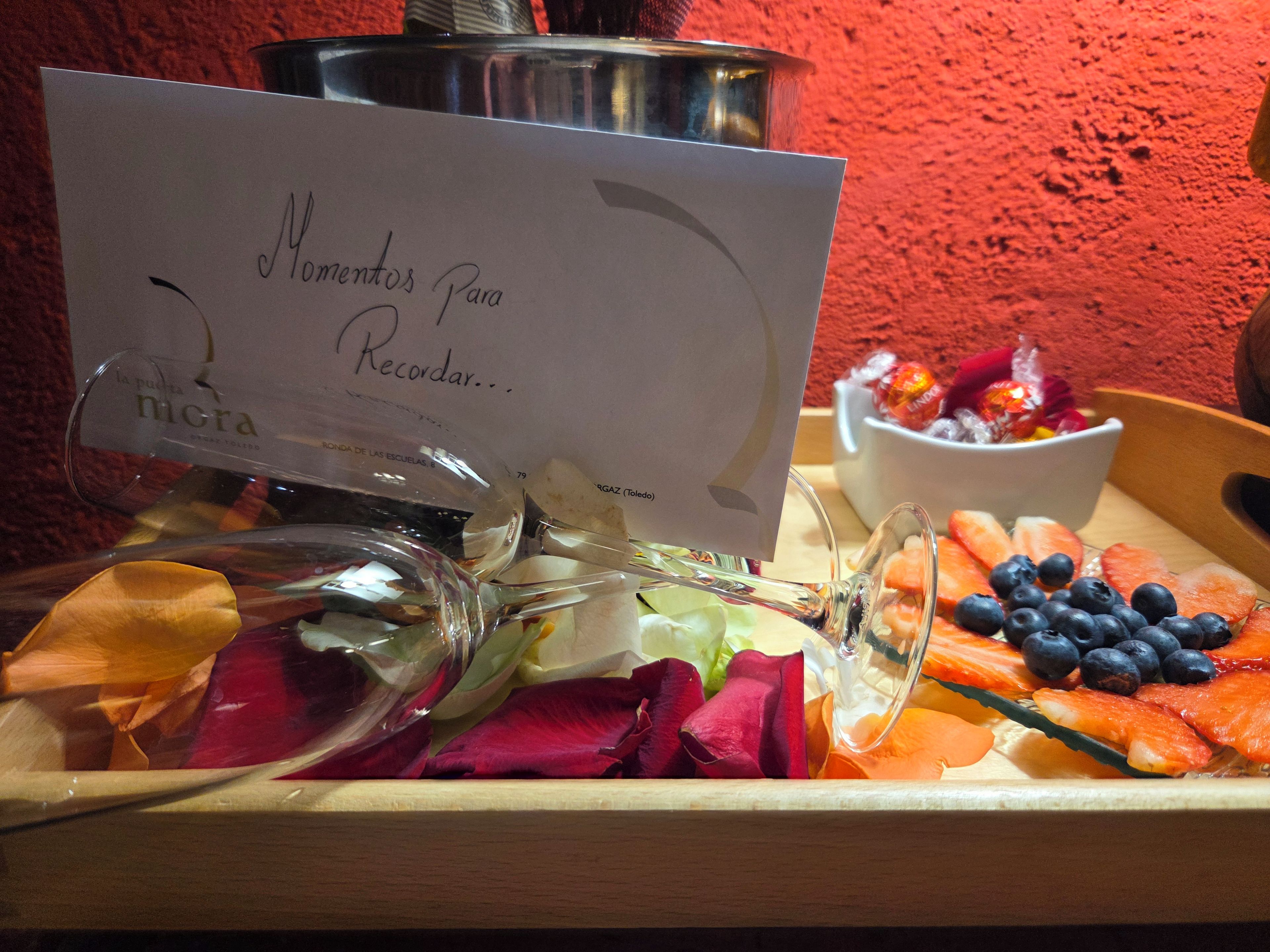 Una bandeja con diversas frutas y una tarjeta con texto.