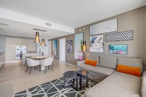 Uma sala de estar moderna com sofá, mesa de centro e área de jantar com cadeiras.