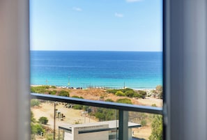 A view of the sea from a window with a building in the foreground. - Premium 6BR Coastal Stay in Achziv by SeaNRent (Nahariya)