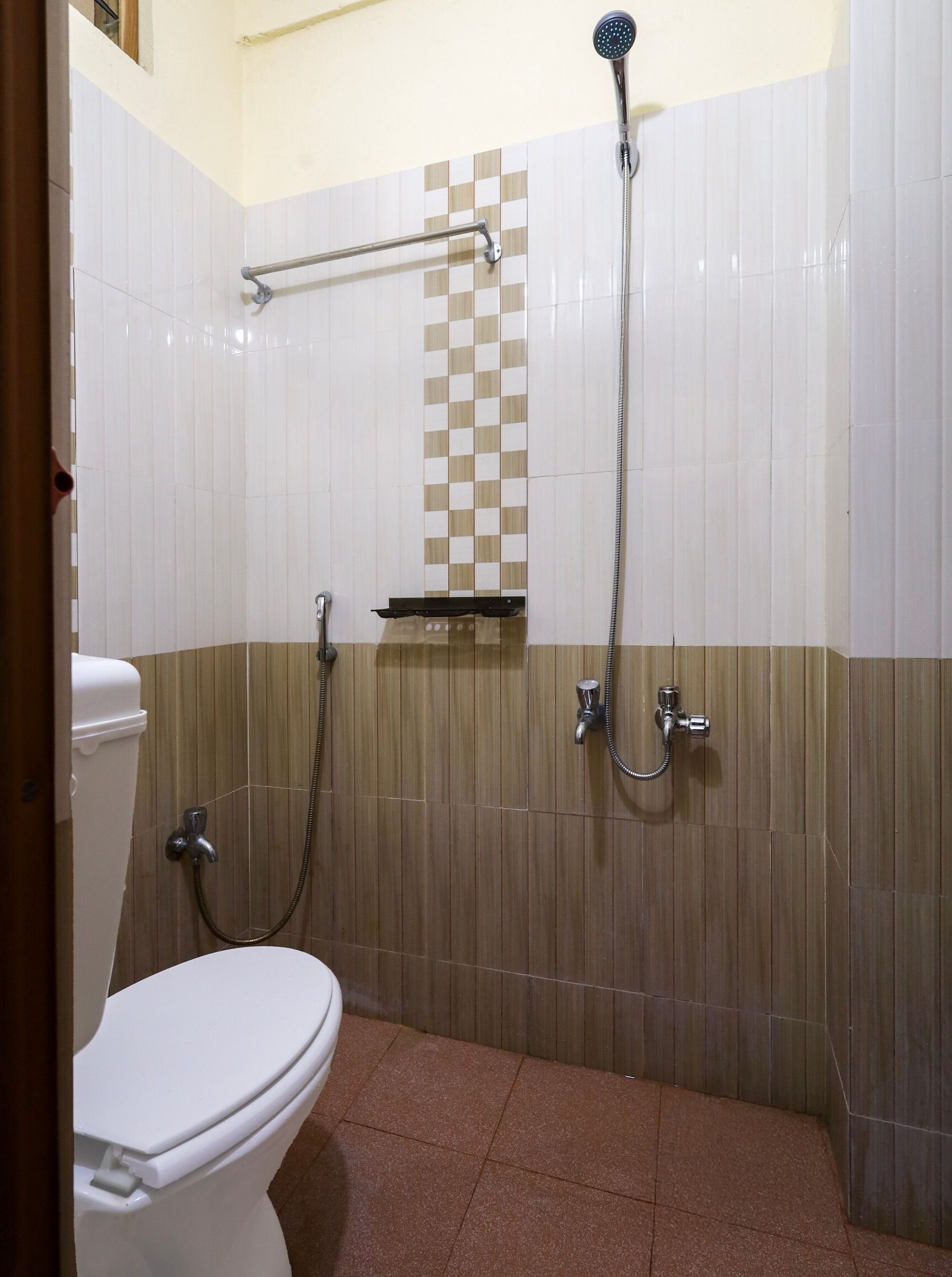 A bathroom with a toilet, a shower, and a towel rack.