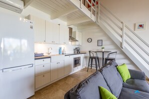 A modern kitchen with white cabinets, a stainless steel range hood, and a built-in oven. - 2BR Duplex, Sunset Views, Sleeps 4 · Apt 55 Ocean Breeze (Kralendijk)