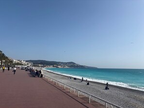 A beach with a paved walkway, people, and a clear sky. - Convenient studio with Wi-Fi near Nice city centre (Nice)