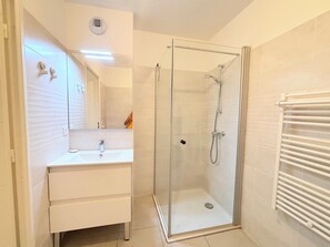 A bathroom with a glass-enclosed shower, a white sink, and a mirror. - Convenient studio with Wi-Fi near Nice city centre (Nice)