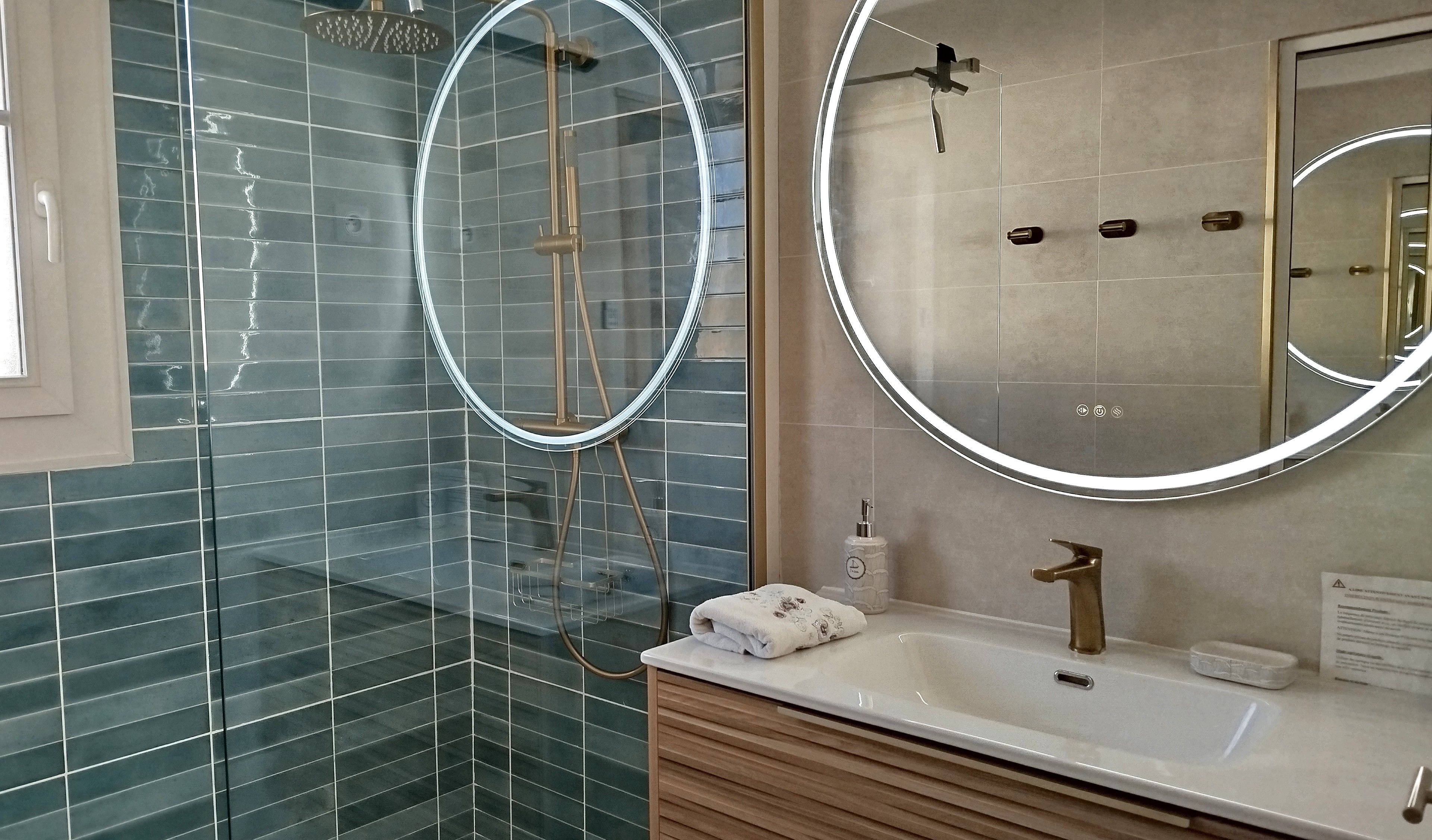 Une salle de bain moderne avec une douche à parois de verre, un meuble-lavabo avec un miroir et une serviette posée sur le comptoir.