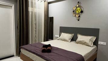 Ein Schlafzimmer mit einem Bett, einem Deckenventilator, einer Wanduhr und einem Fenster mit Vorhängen.