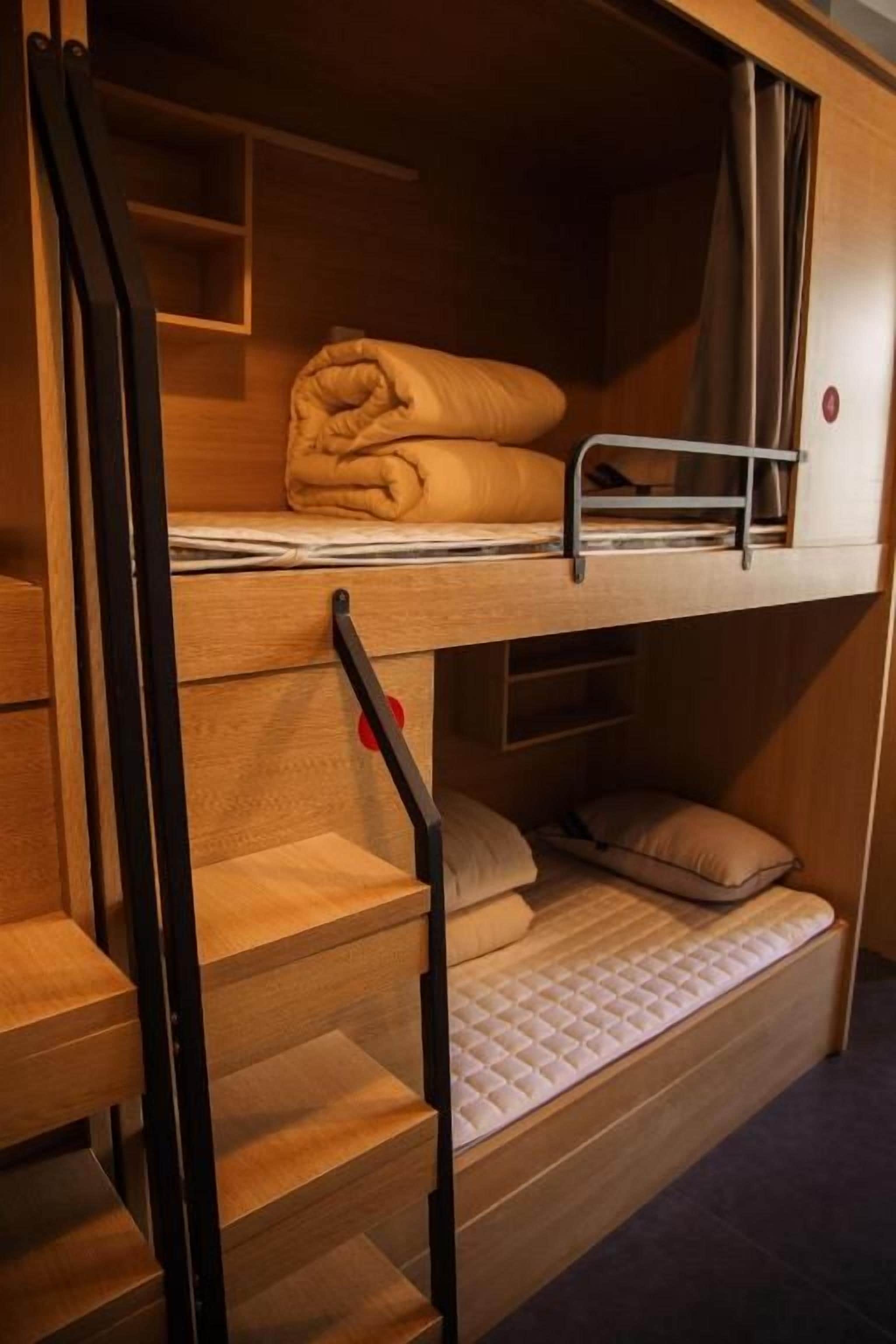 A bunk bed with a mattress, pillows, and a folded blanket.