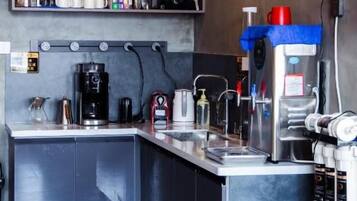 A modern kitchen with a built-in island, coffee machine, and various appliances.