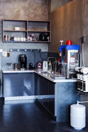 A modern kitchen with a built-in island, coffee machine, and various appliances. - Hostel On The Way (Shayibake Urumqi)