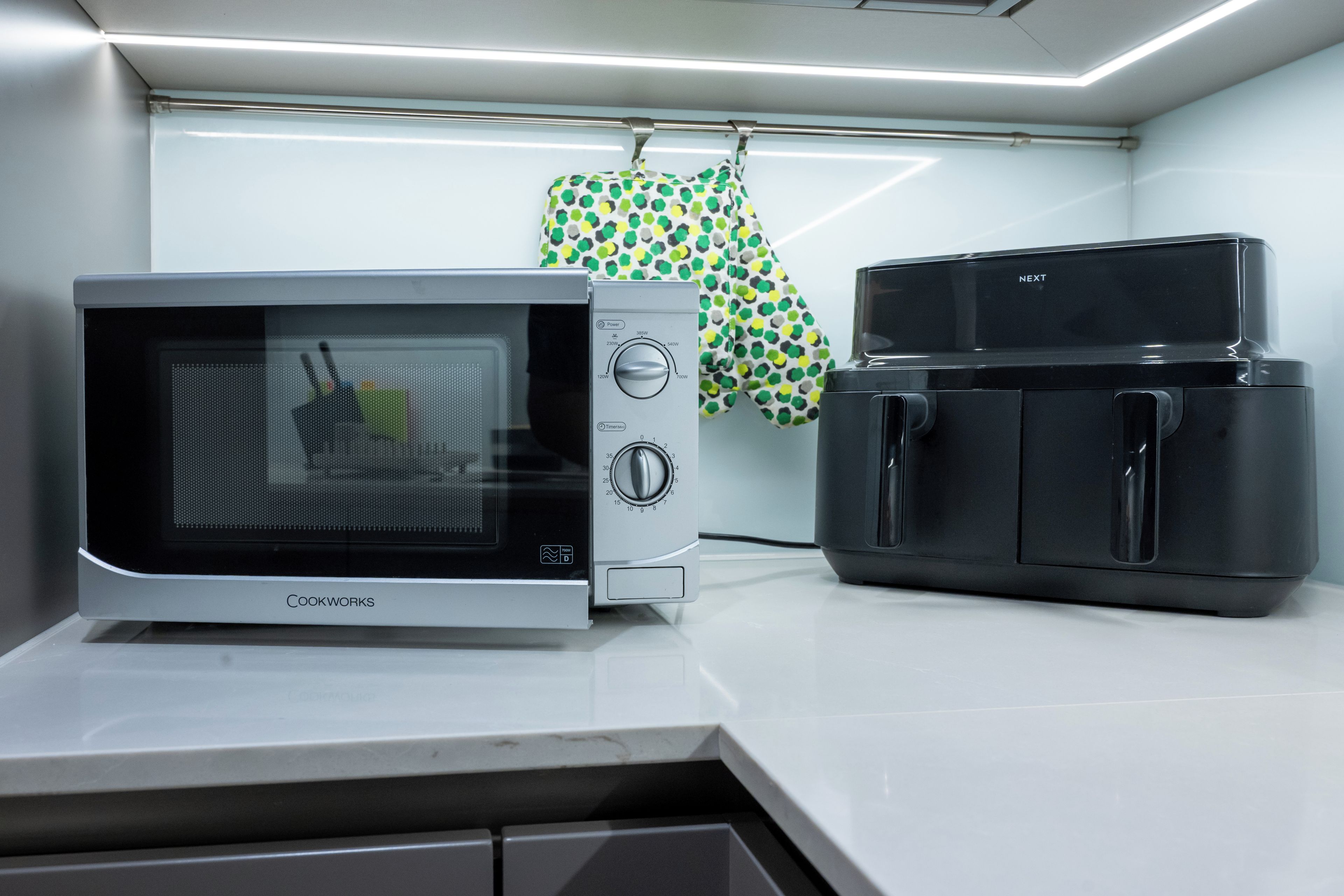 A kitchen with a microwave, a toaster, and a kettle.