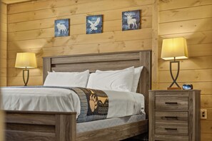 Ein Zimmer mit Holzwänden, einem Bett, zwei Nachttischlampen und drei Wandgemälden.