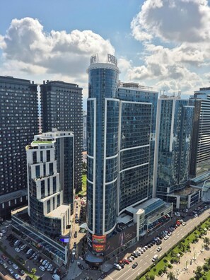 Un edificio de gran altura con fachada de vidrio curva, rodeado de otros edificios altos.
