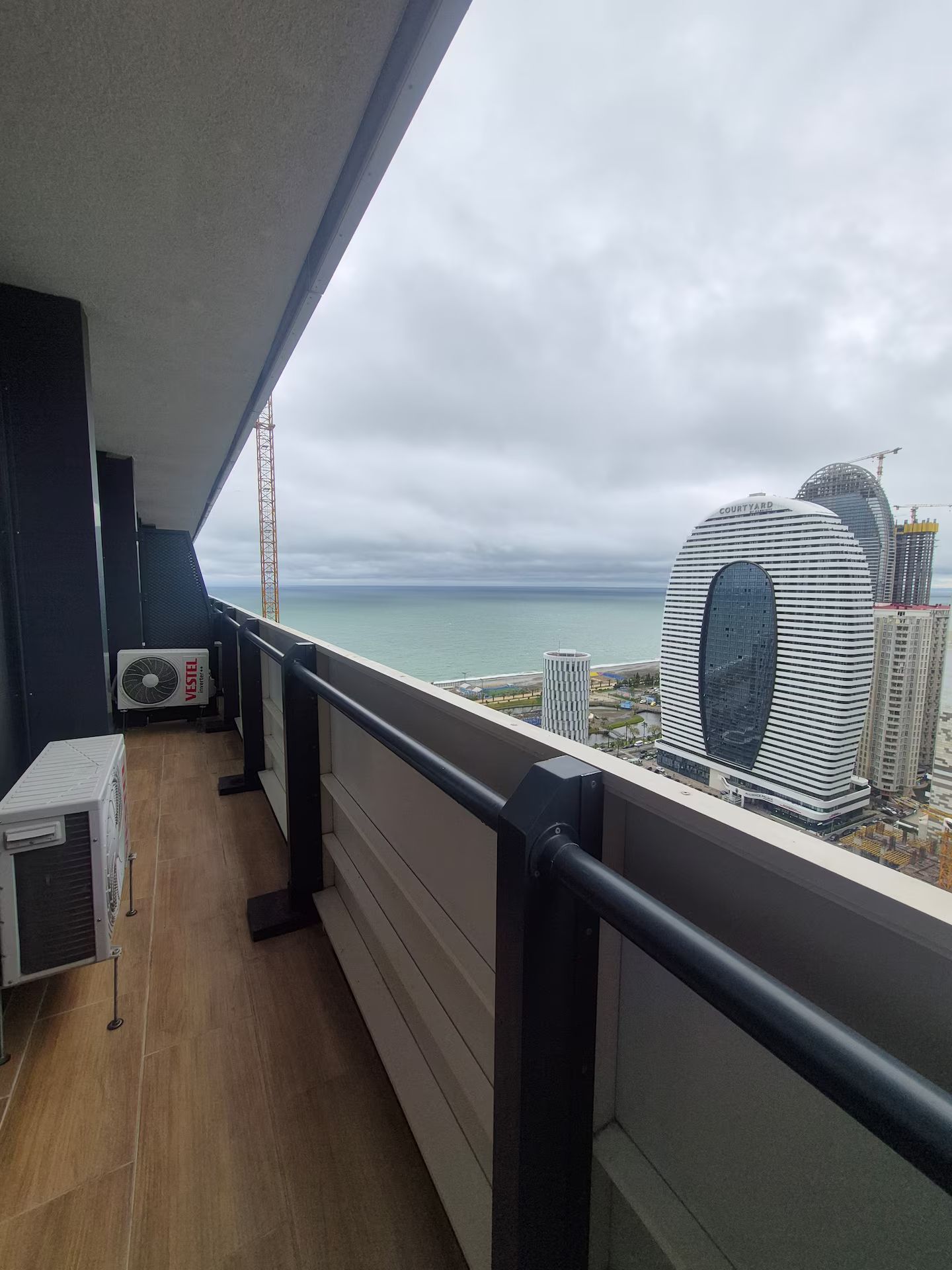 Varanda vista mar e edifício moderno.