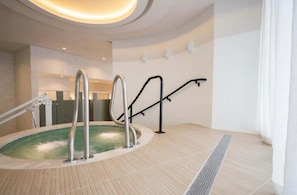 A spa area with a hot tub, metal handrails, and a tiled floor. - The Crosby Downtown 2BR Balcony & City Views (Miami)