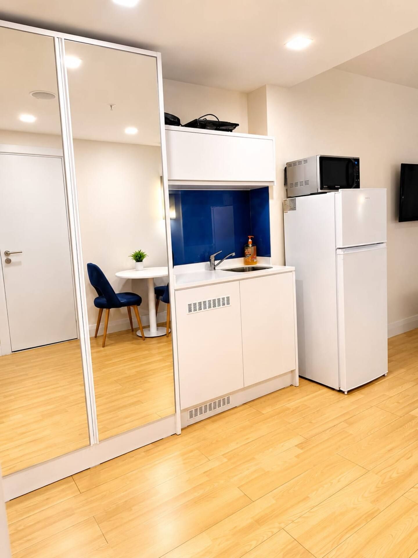 Une petite cuisine équipée d’un four à micro-ondes, d’un réfrigérateur et d’un petit évier.
