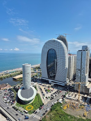 A modern hotel with a distinctive curved facade, a central courtyard, and a view of the sea. - ORBI D2 "14 " Seaview quite studio (Batumi)