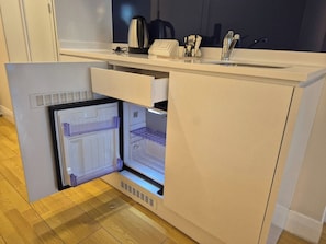 A compact kitchen with a built-in refrigerator, a sink, and a coffee maker. - ORBI D2 "14 " Seaview quite studio (Batumi)