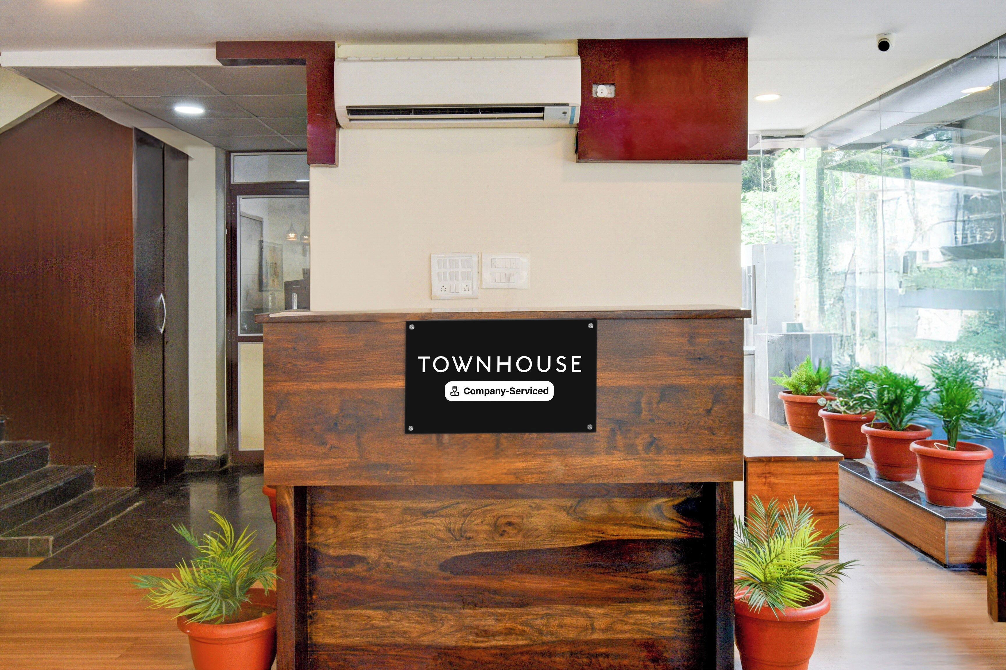 Una mesa de recepción con un cartel que indica 'Townhouse Company Serviced'.