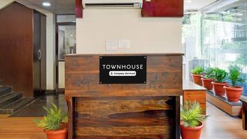 Een receptiebalie met een bordje waarop 'Townhouse Company Serviced' staat.