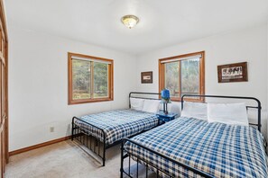 A bedroom with two beds, a window, and a ceiling light. - Spacious 3 Bedroom, 2 Full Bath with Deck, Private Hot Tub and Mountain Views (Blue River)