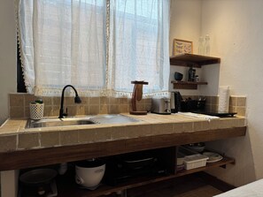 A kitchen with a sink, a toaster, a kettle, and a window with a curtain. - New Listing (Santa Teresa)