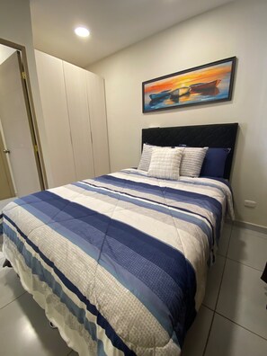 Une chambre à coucher avec un lit, un tableau et une armoire.
