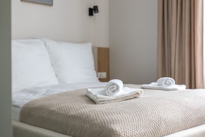 A hotel room with a bed, a bedside table, and a window with curtains. - Armas 4 Sza Wiowy Komfort z Balkonem (Bydgoszcz)