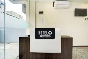 Una mesa de recepción de hotel con un cartel que indica que es un hotel para clientes corporativos.