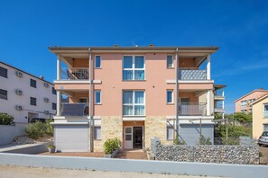 A multi-story residential building with balconies, a stone facade, and a gated entrance. - New Listing (Čižići)